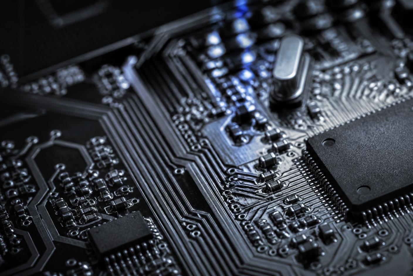 Macro view of a circuit board showing copper traces, surface-mounted components and an integrated circuit