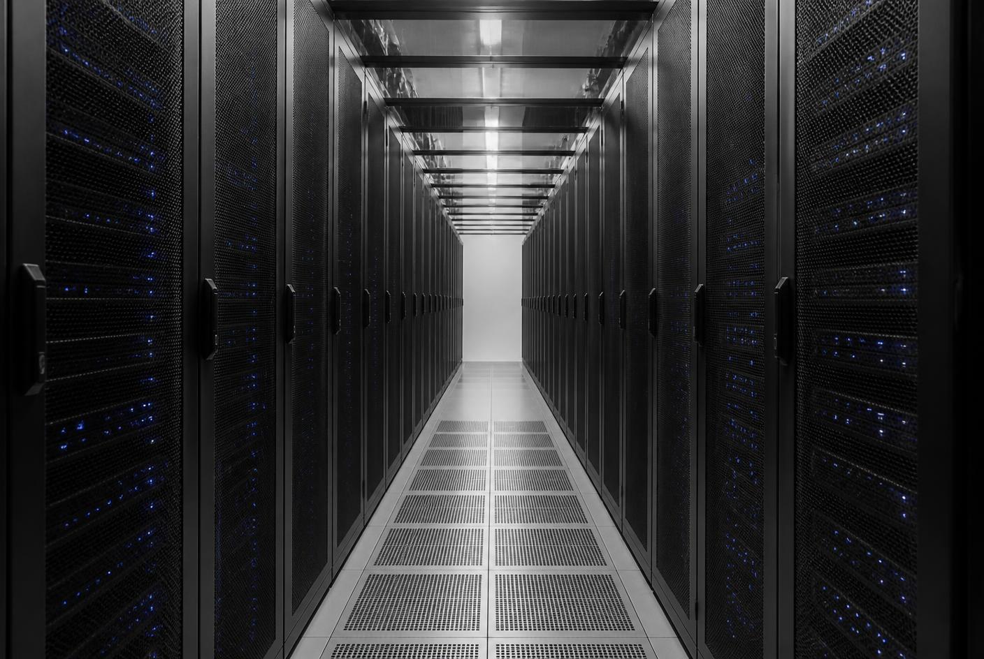 Rows of server racks in a data centre aisle with status indicators visible